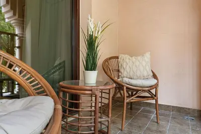 a porch with two chairs and a table and a plant at The Smart Concierge - Andalus Jumeirah Golf Estates in Dubai