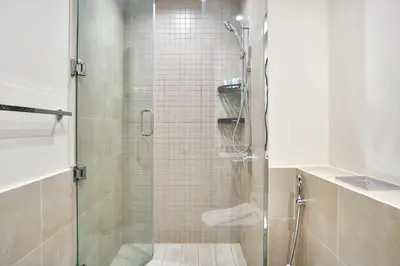 a shower with a glass door in a bathroom at Modern 2BR Apartment with Zabeel Park & Skyline Views in Dubai