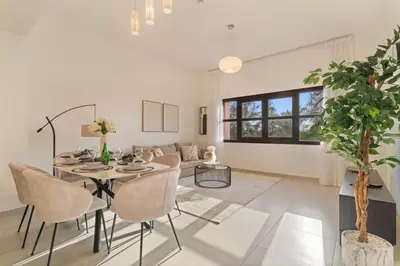 a living room with a table and chairs at The Smart Concierge - Andalus Jumeirah Golf Estates in Dubai