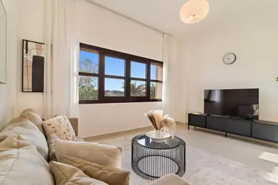 a living room with a couch and a tv at The Smart Concierge - Andalus Jumeirah Golf Estates in Dubai