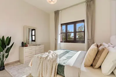 a white bedroom with a bed and a window at The Smart Concierge - Andalus Jumeirah Golf Estates in Dubai