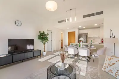 a living room with a kitchen and a dining room at The Smart Concierge - Andalus Jumeirah Golf Estates in Dubai