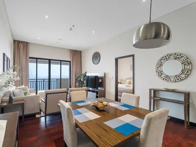 a dining room and living room with a table and chairs at Seaside Serenity 1BR Residence in Royal Amwaj in Dubai