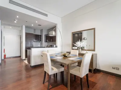 a kitchen and dining room with a wooden table and chairs at Seaside Serenity 1BR Residence in Royal Amwaj in Dubai