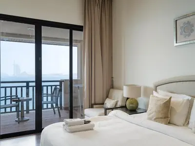 a hotel room with a bed and a balcony at Seaside Serenity 1BR Residence in Royal Amwaj in Dubai