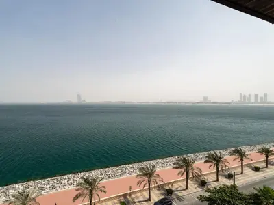 a view of a body of water with palm trees at Seaside Serenity 1BR Residence in Royal Amwaj in Dubai