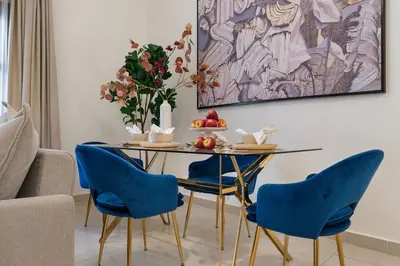 a dining room with a table and blue chairs at The Smart Concierge - Andalus Jumeirah Golf Estates in Dubai