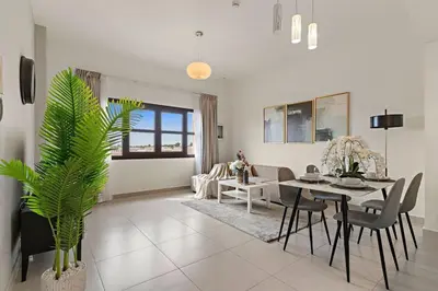 a living room with a table and a dining room at The Smart Concierge - Andalus Jumeirah Golf Estates in Dubai