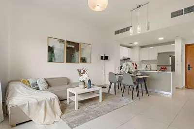 a living room with a couch and a table and a kitchen at The Smart Concierge - Andalus Jumeirah Golf Estates in Dubai