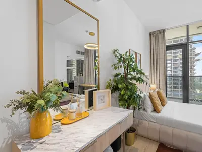 a living room with a bed and a mirror at Warm Glow Retreat Cozy Studio In Regina JVC in Dubai