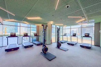 a gym with a bunch of cardio machines in a room at EasyGo - Chic high floor Studio with Burj View in Dubai