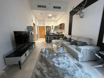 a living room with a couch and a television at Pantheon Elysee in Dubai