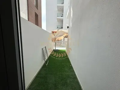 a hallway with green grass on the side of a building at Pantheon Elysee in Dubai
