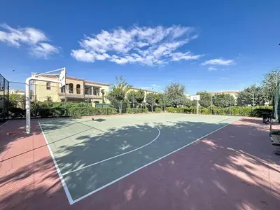 a tennis court in front of a building at Vacationer l Serene 2 Bed Villa l Lush Garden l Family Friendly in Nadd Shubayḩ