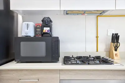 a microwave sitting on top of a stove in a kitchen at Chic 1BR at The Bay - Business Bay Near Burj Khalifa & Dubai Mall in Dubai