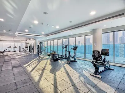 a gym with treadmills and cardio equipment in a building at Chic 1BR at The Bay - Business Bay Near Burj Khalifa & Dubai Mall in Dubai