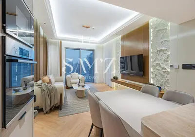 a living room with a couch and a table and a tv at Stylish 2BR in Downtown Views - High Floor 2906 in Dubai