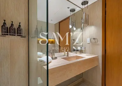 a bathroom with a sink and a sign that says swim holidays at Stylish 2BR in Downtown Views - High Floor 2906 in Dubai