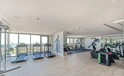 a gym with treadmills and exercise equipment in a building at Designer 1BR Dubai Creek Harbour in Dubai