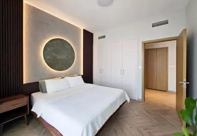 a bedroom with a white bed and a painting on the wall at Designer 1BR Dubai Creek Harbour in Dubai