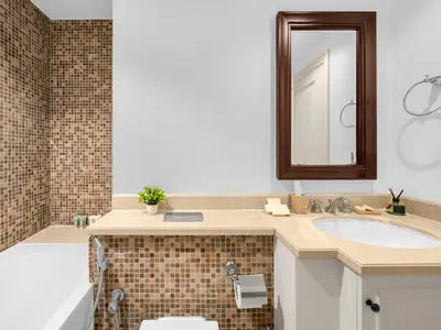 a bathroom with a sink and a tub and a mirror at Luxury 2BR- Pool with Burj View- 5 Min to Dubai Mall in Dubai