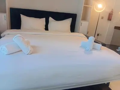 a white bed with two towels on it at Studio Hide Away in the Business Bay in Dubai