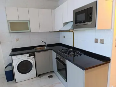 a kitchen with a washing machine and a microwave at Studio Hide Away in the Business Bay in Dubai