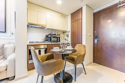 a kitchen and dining room with a table and chairs at Vibrant City Living, 1Bedroom with Balcony - Vera Tower, Business Bay by Deluxe Holiday Homes in Dubai