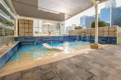 a swimming pool with a slide in the water at Vibrant City Living, 1Bedroom with Balcony - Vera Tower, Business Bay by Deluxe Holiday Homes in Dubai