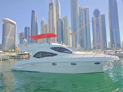 a white boat in the water in front of a city at Luxury yacht Stay Dubai in Dubai