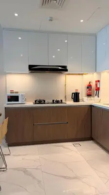 a kitchen with white cabinets and a stove top oven at Contemporary 1 Bedroom in the Heart of Al Furjan-205 in Dubai