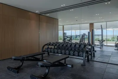 a gym with treadmills and machines in a room at Modern Studio in Binghatti Azure with Pool & Gym in Dubai