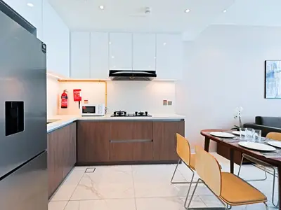 a kitchen and dining room with a table and chairs at Spacious 1BR with Modern Living in Al Furjan-805 in Dubai