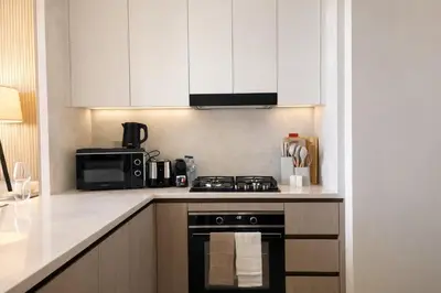 a kitchen with a stove and a microwave at Binghatti Royale Luxe 1BR W Private Pool Parking in Dubai