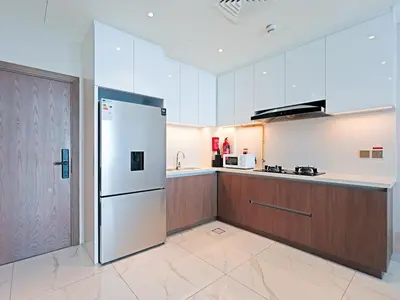 a kitchen with a refrigerator and a counter top at Exclusive 2BR Apartment - Prime Al Furjan-707 in Dubai