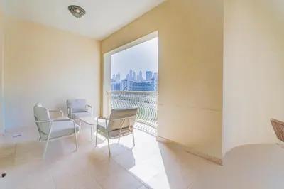 a room with two chairs and a large window at HAVN - Spacious 2 Bed in Al Hallawi, Palm Jumeirah in Dubai
