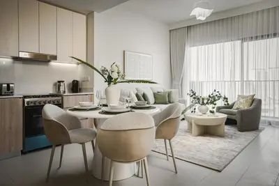 a kitchen and living room with a table and chairs at Daniels 1BR in Dubai Hills with Park View in Dubai