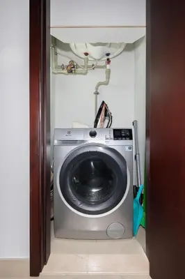 a washer and dryer in a room at Elegant 2BR Balcony and Stunning Burj Views in Dubai