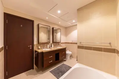 a bathroom with a tub and a sink and a toilet at Elegant 2BR Balcony and Stunning Burj Views in Dubai