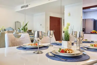 a table with plates of food and wine glasses at 3-Bedroom Residence in Murjan 5 - Jumeirah Beach with Sea Views in Dubai