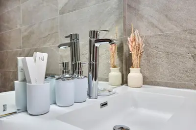 a bathroom counter with a sink with a group of faucets at 3-Bedroom Residence in Murjan 5 - Jumeirah Beach with Sea Views in Dubai