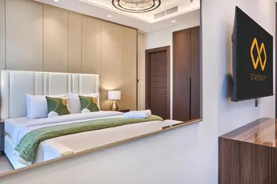 a bedroom with a large bed and a tv at Nobles Tower Business Bay - Modern 1-Bedroom Apartment in Dubai