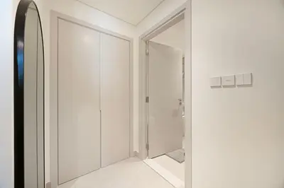 a white bathroom with a door and a mirror at Classy Stay at Beach Mansion with Private Beach in Dubai