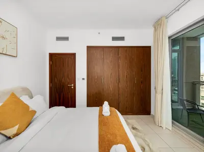 a bedroom with a bed and a wooden door at By Luxury Space I Luxury two Bedroom Apartment I Front row Downtown with Private Fountain View in Dubai