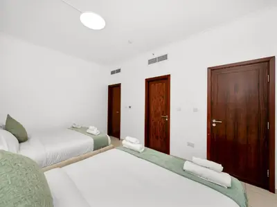 a white bedroom with two beds and a closet at By Luxury Space I Luxury two Bedroom Apartment I Front row Downtown with Private Fountain View in Dubai