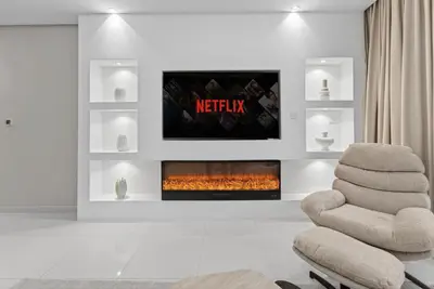 a living room with a fireplace and a chair at Paramount 59th Floor , Burj View Infinity Pool in Dubai