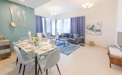 a dining room and living room with a table and chairs at Cozy and modern 1 BR Apt in Al Furjan in Dubai