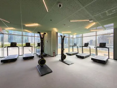 a gym with a bunch of treadms and machines at 35 eme étage panoramique vue mer ,vue Burj Khalifa et Burj el araabe in Dubai