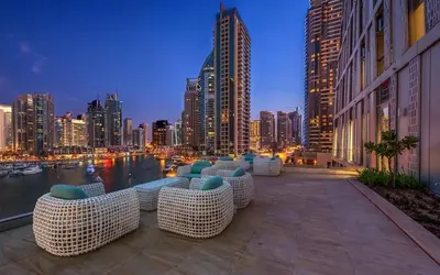 a view of a city skyline at night with tables and chairs at Artistic Studio in Cayan Tower with Marina Views in Dubai