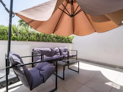 a table and chairs under an umbrella on a patio at Homely Bliss Studio in Azizi Riviera-12 in Dubai